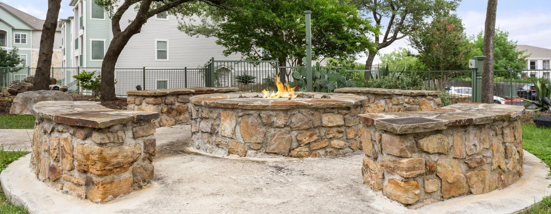 stone, outdoor fire pit surrounded by stone benches