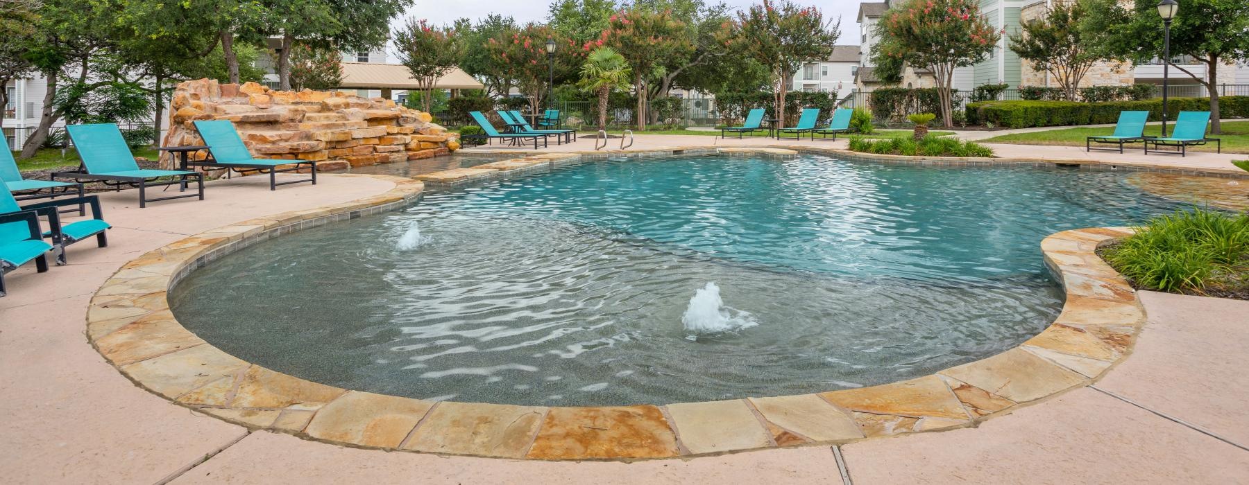 swimming pool with tanning shelf and fountains